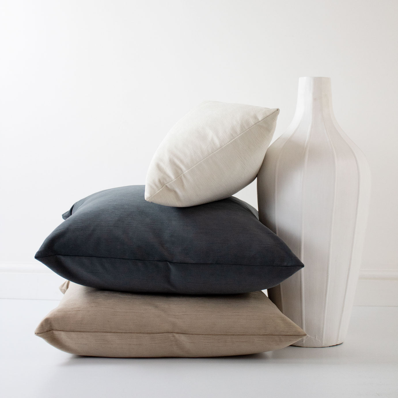 cojines grises, beige y blanco con jarrón